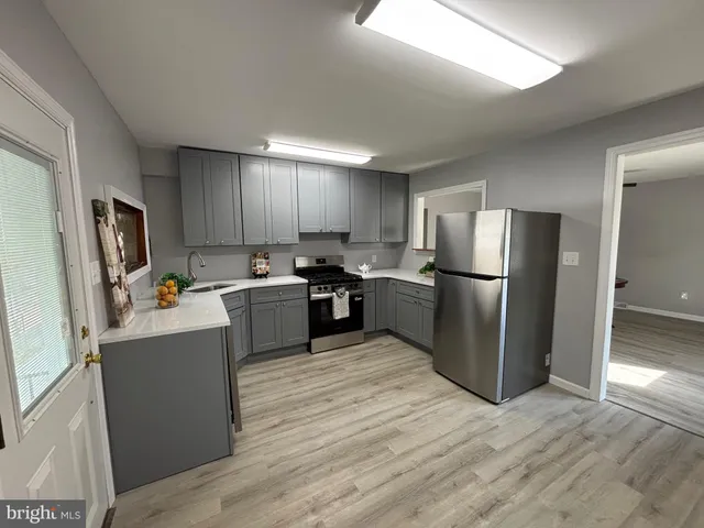 a kitchen with stainless steel appliances a refrigerator and a stove top oven
