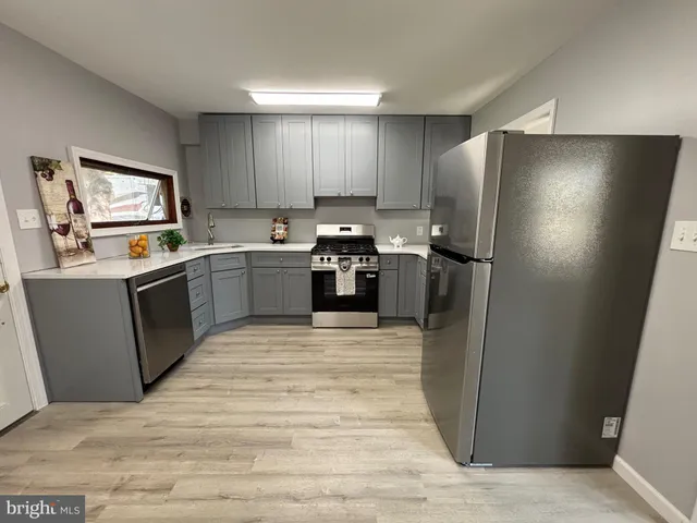 a kitchen with stainless steel appliances granite countertop a refrigerator stove and sink