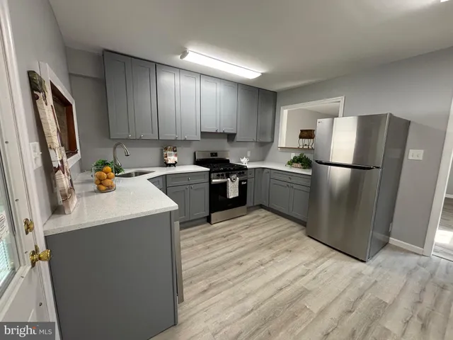 a kitchen with a sink a refrigerator a microwave and cabinets