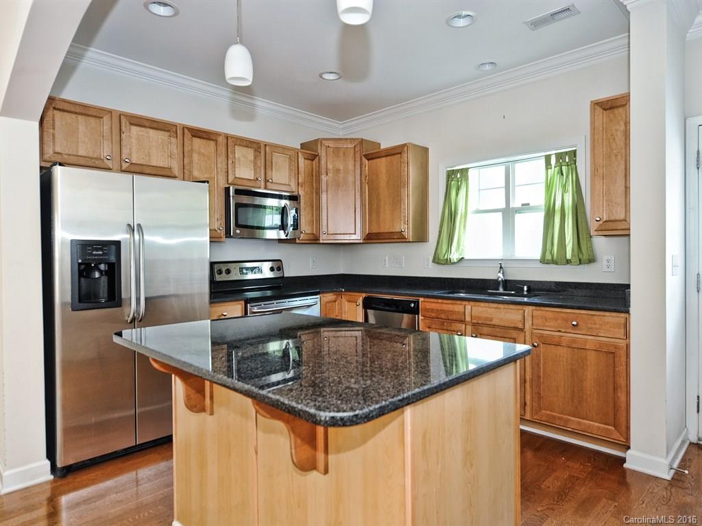 4142 Walker Road, Unit 4142 Charlotte, NC 28211 - Photo 8 of 22 a kitchen with stainless steel appliances granite countertop a sink a microwave counter space and wooden floor