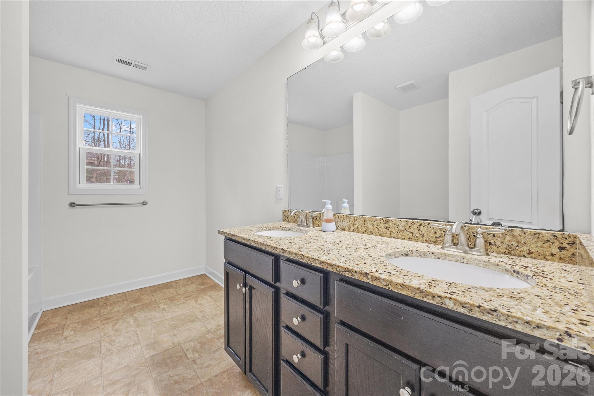 6115 Chandler Road Clover, SC 29710 - Photo 22 of 36 a bathroom with a granite countertop sink a large mirror and a