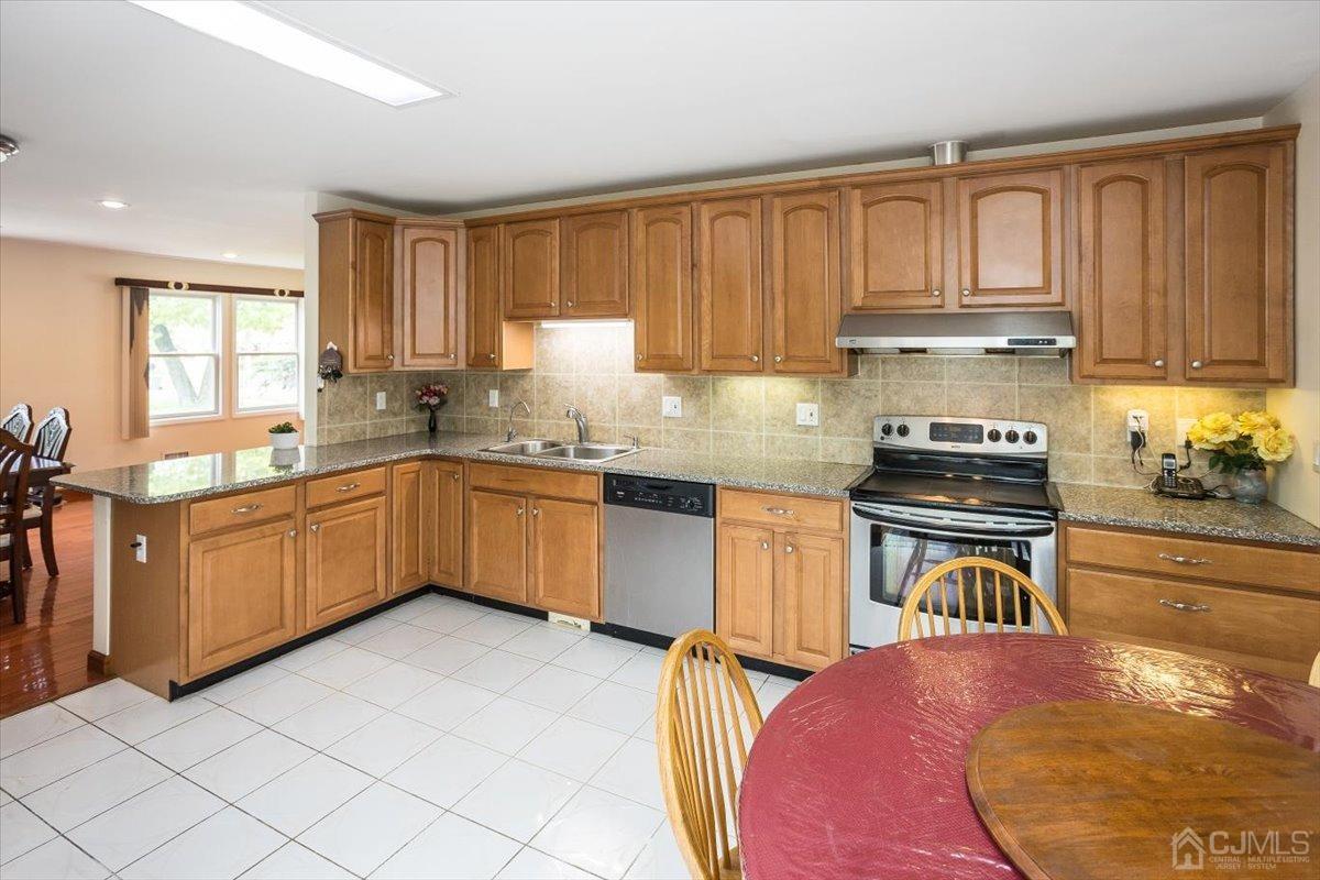19 Elizabeth Avenue Edison, NJ 08820 - Photo 15 of 48 a kitchen with granite countertop a sink a counter top space appliances and cabinets