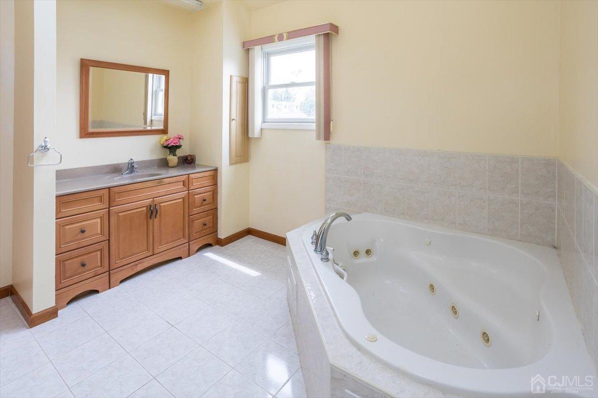 19 Elizabeth Avenue Edison, NJ 08820 - Photo 28 of 48 a bathroom with a tub sink and mirror