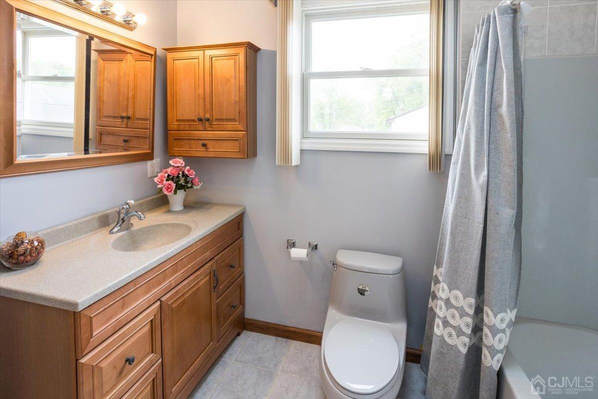 19 Elizabeth Avenue Edison, NJ 08820 - Photo 33 of 48 a bathroom with a toilet sink vanity and mirror