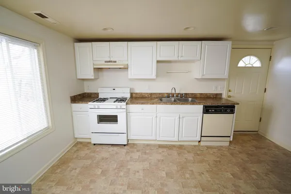 a kitchen with granite countertop white cabinets and white appliances