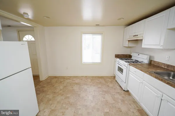 a kitchen with granite countertop white cabinets and white appliances