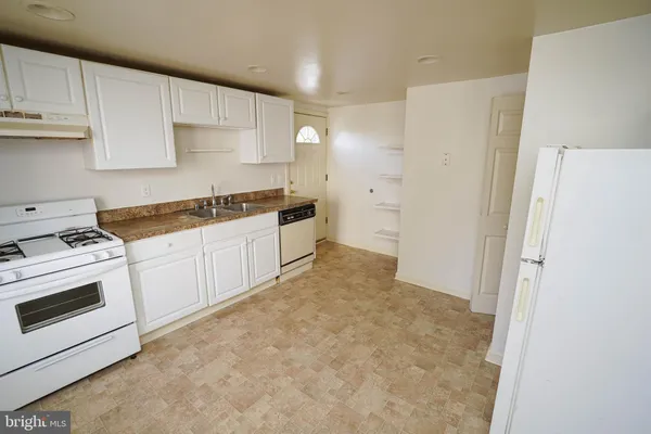 a kitchen with a stove a sink and a refrigerator
