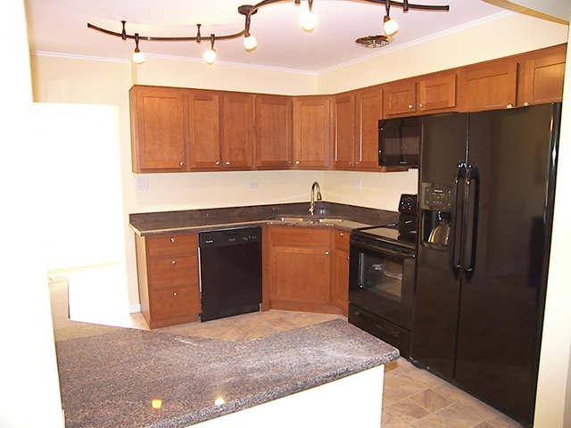 1040 Midway Road Northbrook, IL 60062 - Photo 7 of 18 a kitchen with a refrigerator sink and cabinets