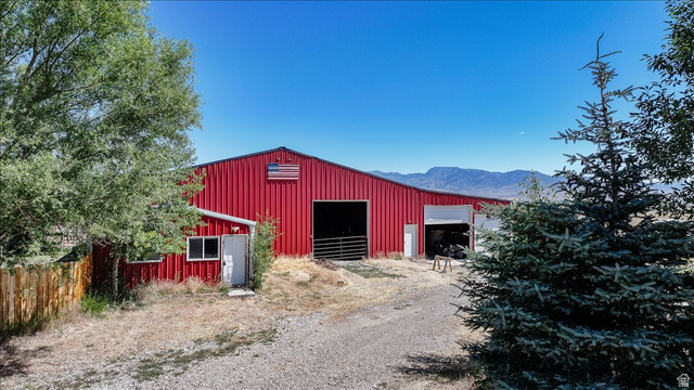 1634 West Arimo Road Arimo, ID 83214 - Photo 61 of 89 Red metal barn structure featuring multiple large bay openings and a separate side entrance