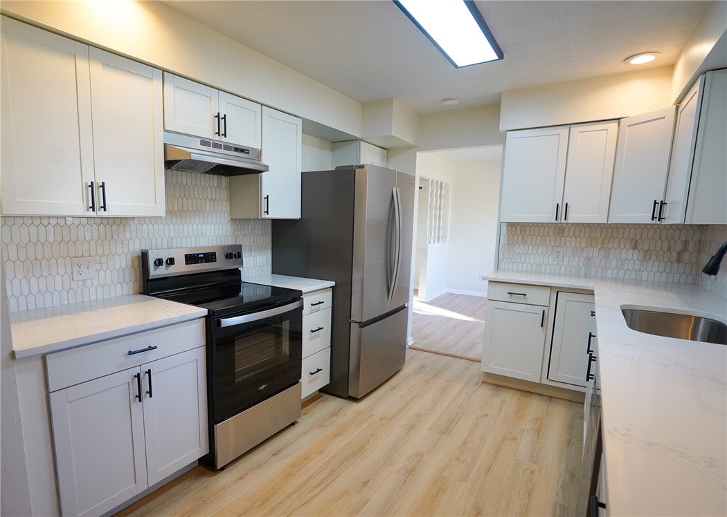 8746 Grubbs-Rex Road Arcanum, OH 45304 - Photo 34 of 38 This modern kitchen features crisp cabinetry and integrated appliances for a seamless culinary experience.