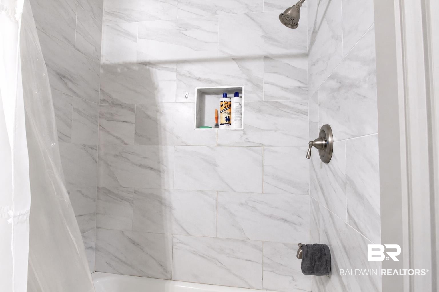 9825 Wolf Creek Ridge Elberta, AL 36530 - Photo 24 of 76 Bathtub and shower combination featuring large format marble-look tile, built-in shower niche, and brushed nickel fixtures
