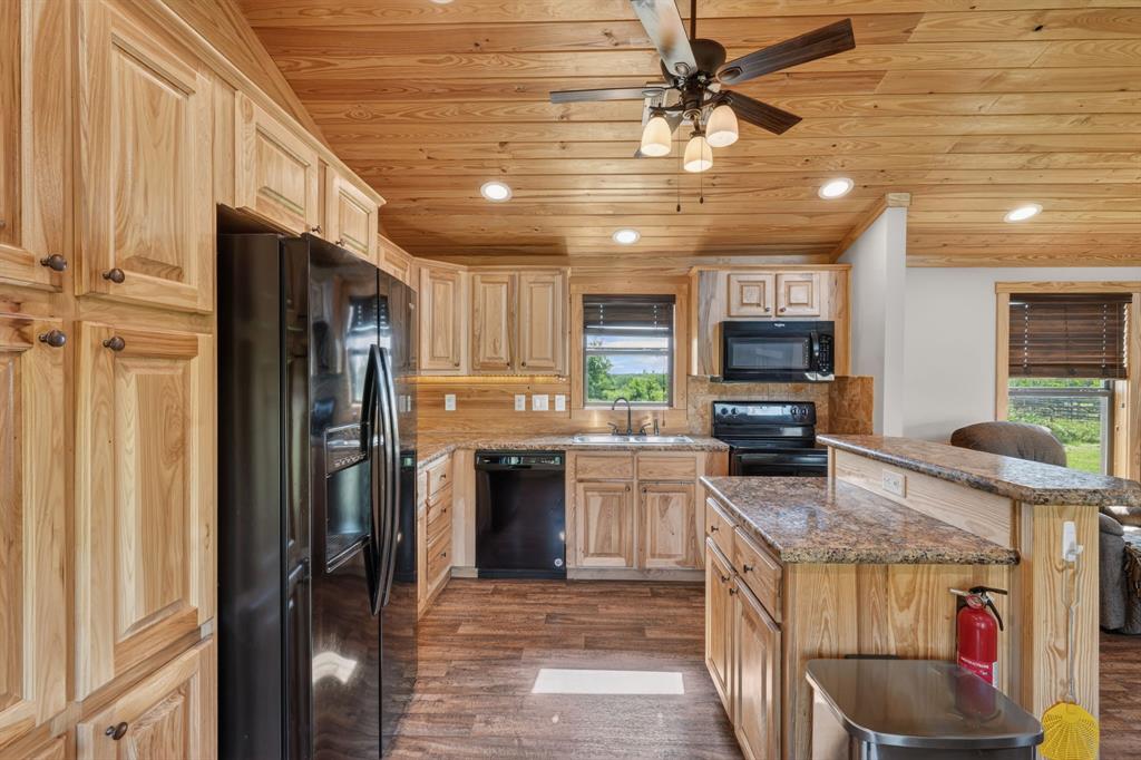2401 Lamkin Road Mineral Wells, TX 76067 - Photo 15 of 36 a kitchen with stainless steel appliances granite countertop a refrigerator a stove and a sink with cabinets