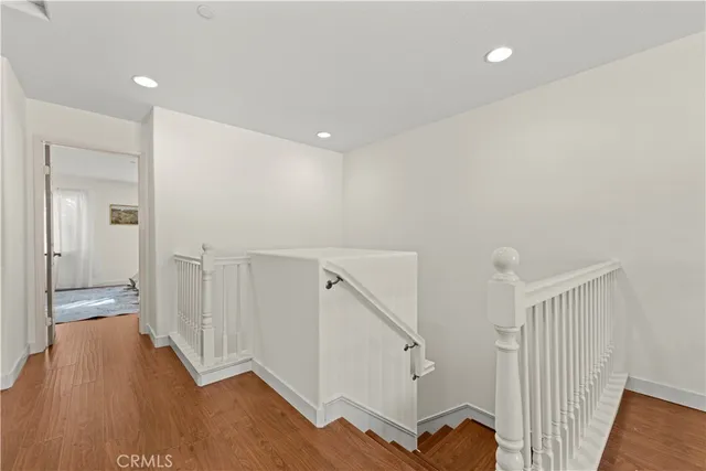 a view of a hallway with wooden floor and staircase