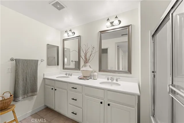 a bathroom with a double vanity sink and mirror