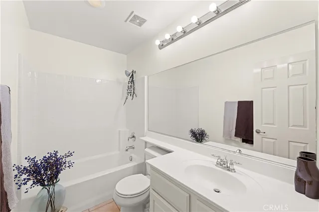 a bathroom with a bathtub shower sink mirror and toilet