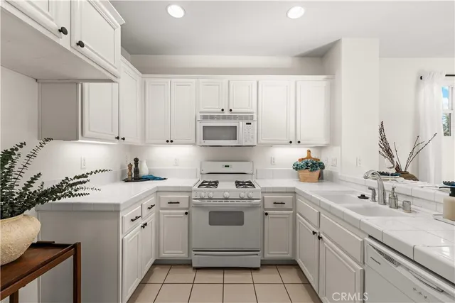 a kitchen with white cabinets appliances and sink