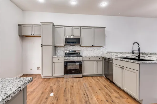 a kitchen with a sink stove and refrigerator