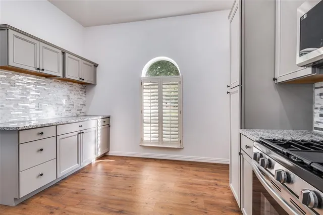 a kitchen with granite countertop a white cabinets and a stove
