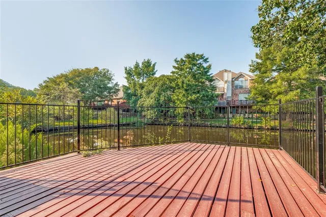 a view of river and deck with wooden floor and fence
