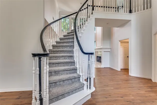 a view of staircase with wooden floor and a chandelier