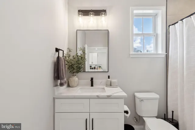 a bathroom with a toilet a sink and mirror