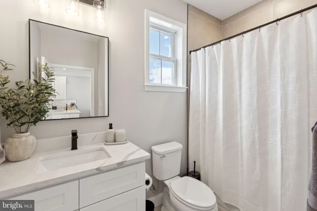 a bathroom with a toilet a sink and a mirror