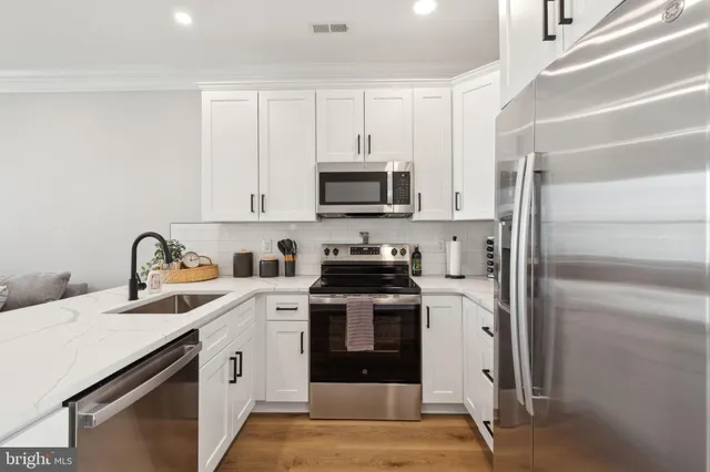 a kitchen with stainless steel appliances granite countertop a stove a sink and a refrigerator