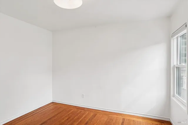 a view of a small space with wooden floor and a window
