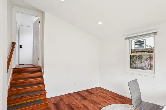 a view of a hallway with wooden floor and a workspace