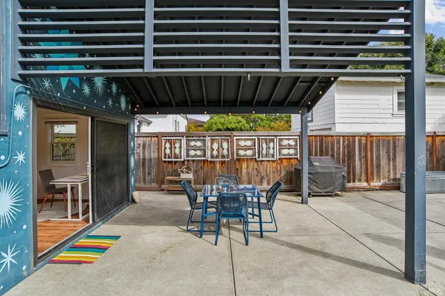 a view of a patio with table and chairs potted plants with wooden floor and fence