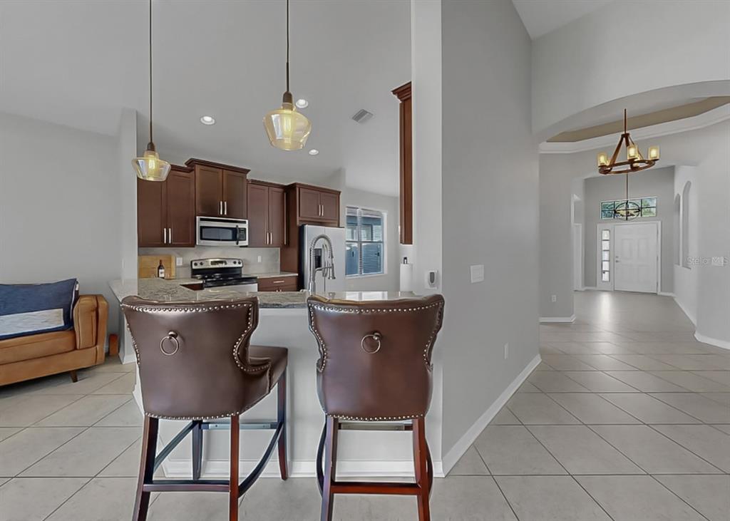 7109 Spindle Tree Lane Riverview, FL 33578 - Photo 30 of 42 a kitchen with a dining table chairs and view of living room