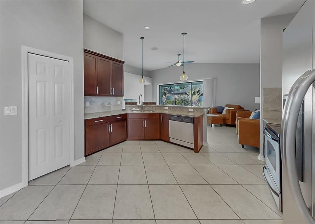 7109 Spindle Tree Lane Riverview, FL 33578 - Photo 31 of 42 a kitchen with stainless steel appliances granite countertop a refrigerator and a sink
