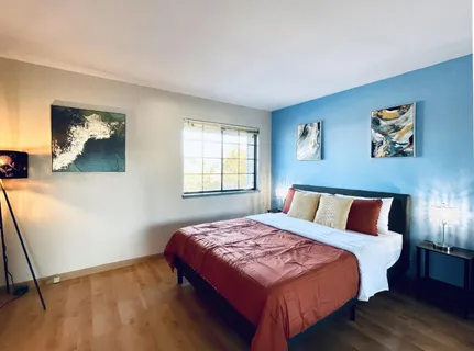 a bedroom with a bed and a painting on the wall