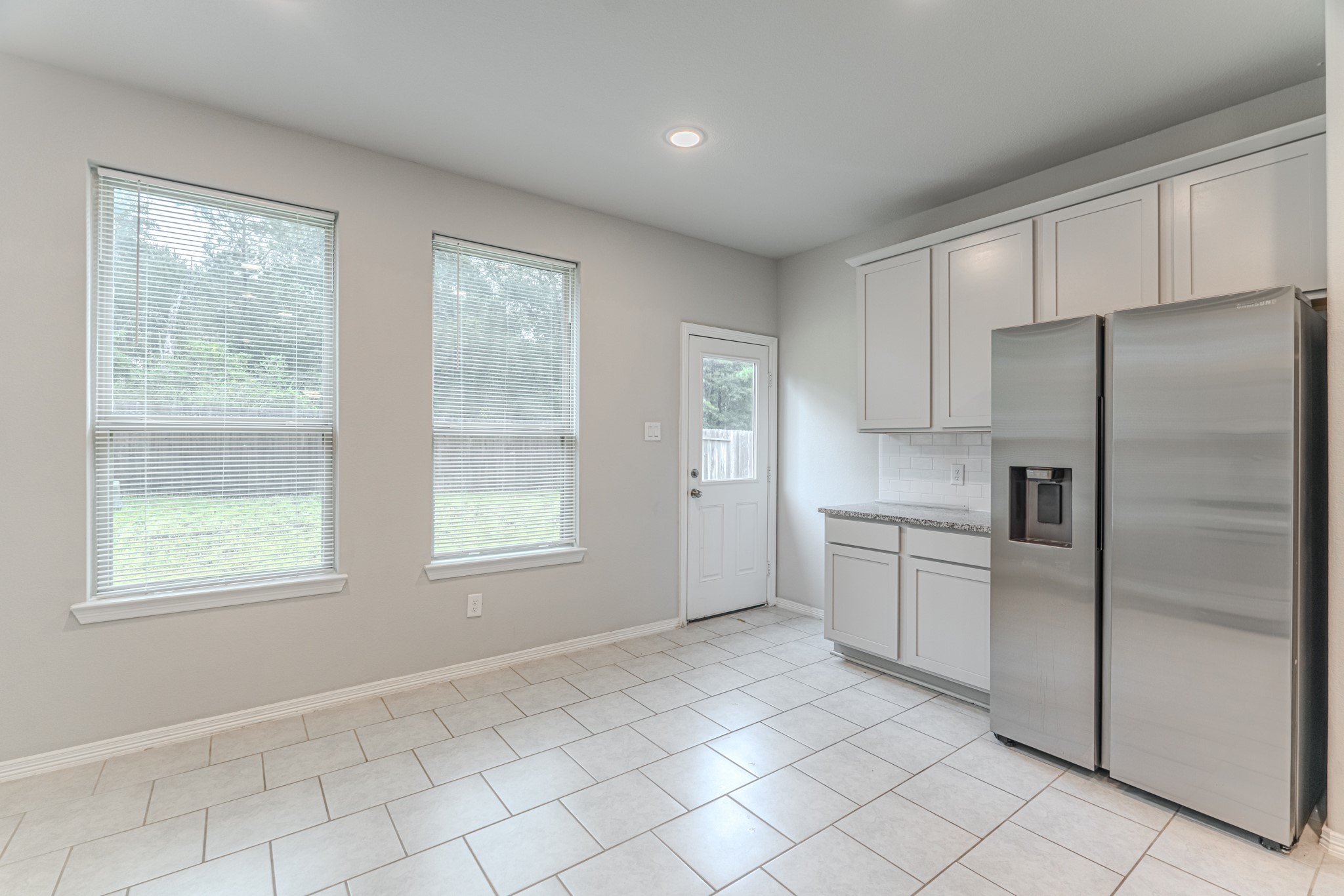 25706 Boxwood Hedge Lane Tomball, TX 77375 - Photo 19 of 44 a kitchen with white cabinets and refrigerator