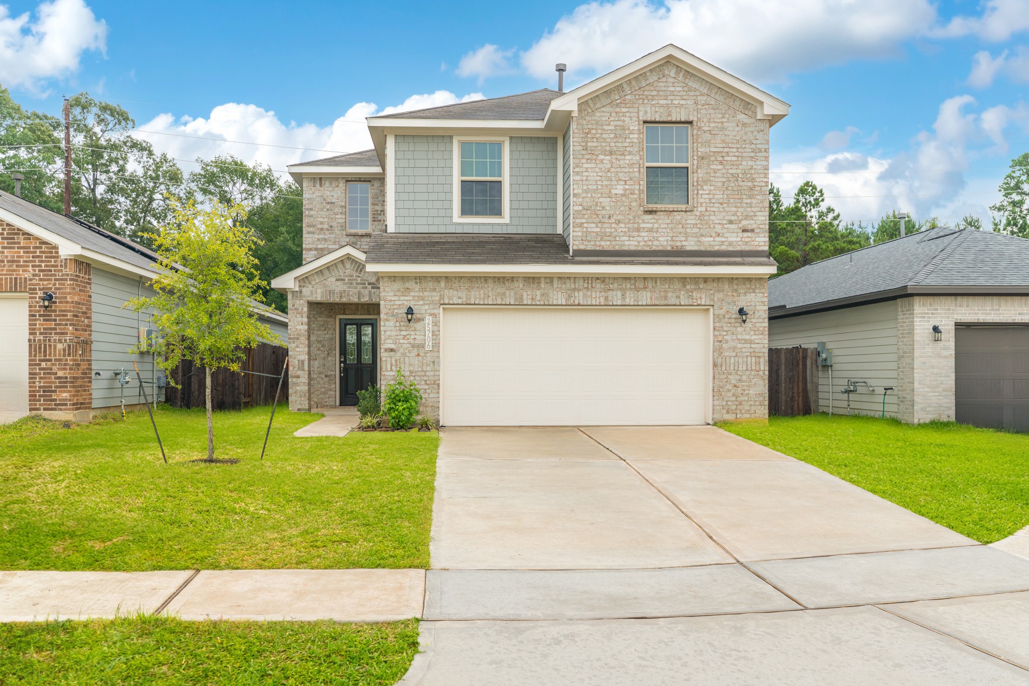 25706 Boxwood Hedge Lane Tomball, TX 77375 - Photo 3 of 44 a front view of a house with a yard and garage