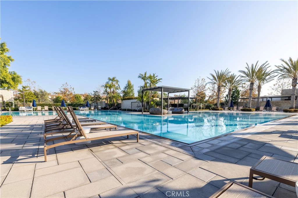 83 Lunar Irvine, CA 92618 - Photo 73 of 75 a view of a swimming pool with a lounge chair and palm trees