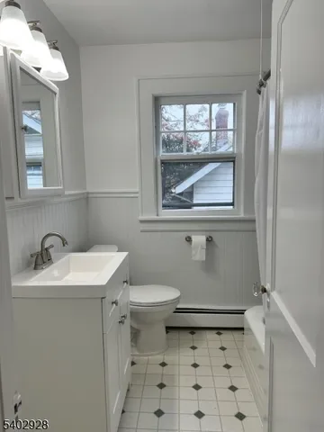 a bathroom with a sink toilet and window