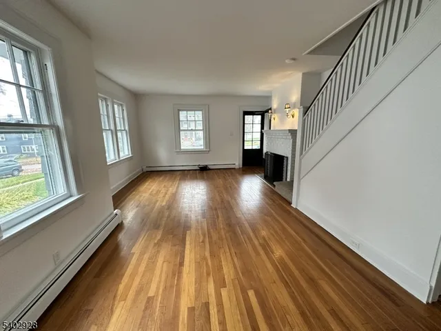 a view of wooden floor in an empty room with a window