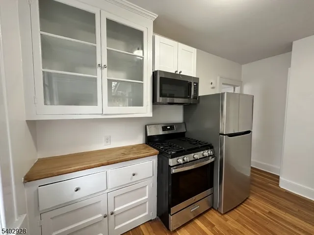 a kitchen with stainless steel appliances a stove a microwave and a sink