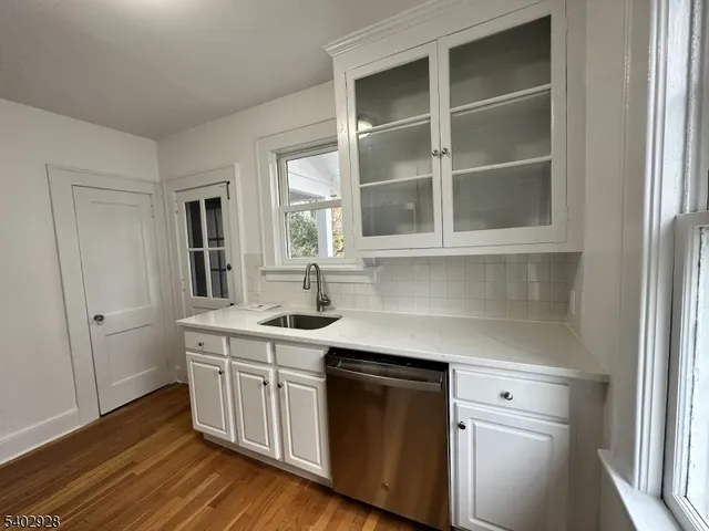 a kitchen with a sink cabinets and wooden floor