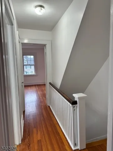 a view of a hallway view with wooden floor and staircase