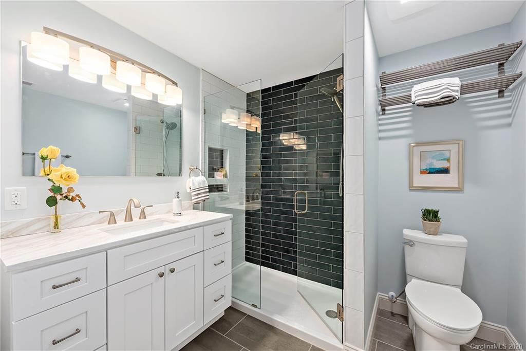 1416 Cortland Road East Charlotte, NC 28209 - Photo 16 of 26 a bathroom with a double vanity sink toilet and shower