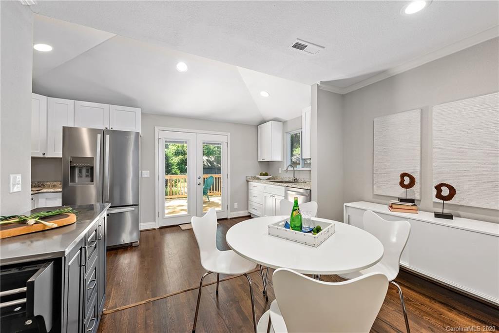 1416 Cortland Road East Charlotte, NC 28209 - Photo 19 of 26 a kitchen with stainless steel appliances a dining table chairs and refrigerator