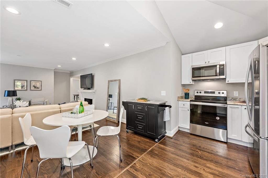 1416 Cortland Road East Charlotte, NC 28209 - Photo 21 of 26 a kitchen with a stove a microwave and a dining table