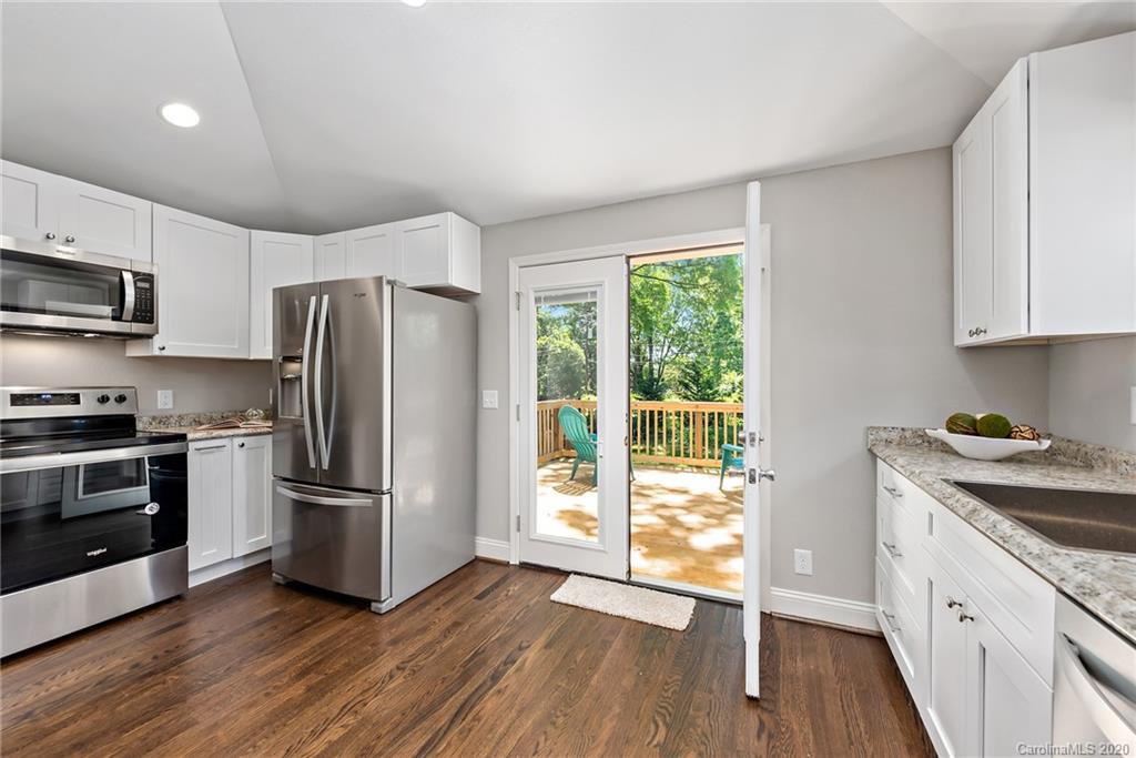 1416 Cortland Road East Charlotte, NC 28209 - Photo 6 of 26 a kitchen with a refrigerator stove and wooden cabinets