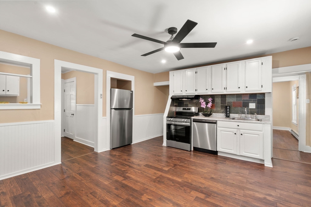 448 Washington Street Warren, MA 01083 - Photo 7 of 42 a kitchen with granite countertop a refrigerator oven a sink dishwasher and white cabinets with wooden floor