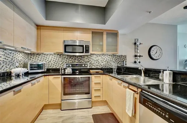 a kitchen with a sink and stainless steel appliances