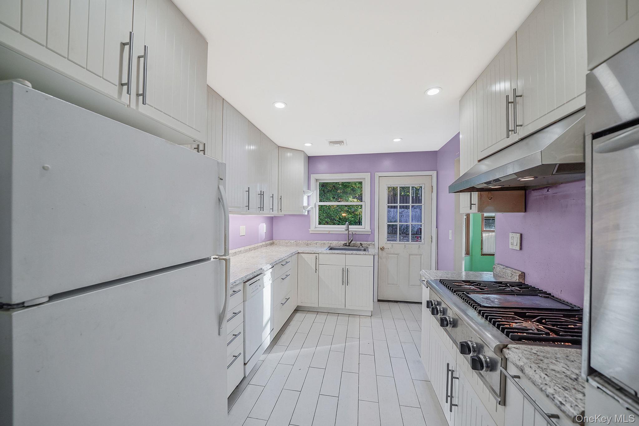 97 Locust Drive Rocky Point, NY 11778 - Photo 11 of 26 Kitchen featuring stainless steel appliances, under cabinet range hood, recessed lighting, light stone countertops, and white cabinets