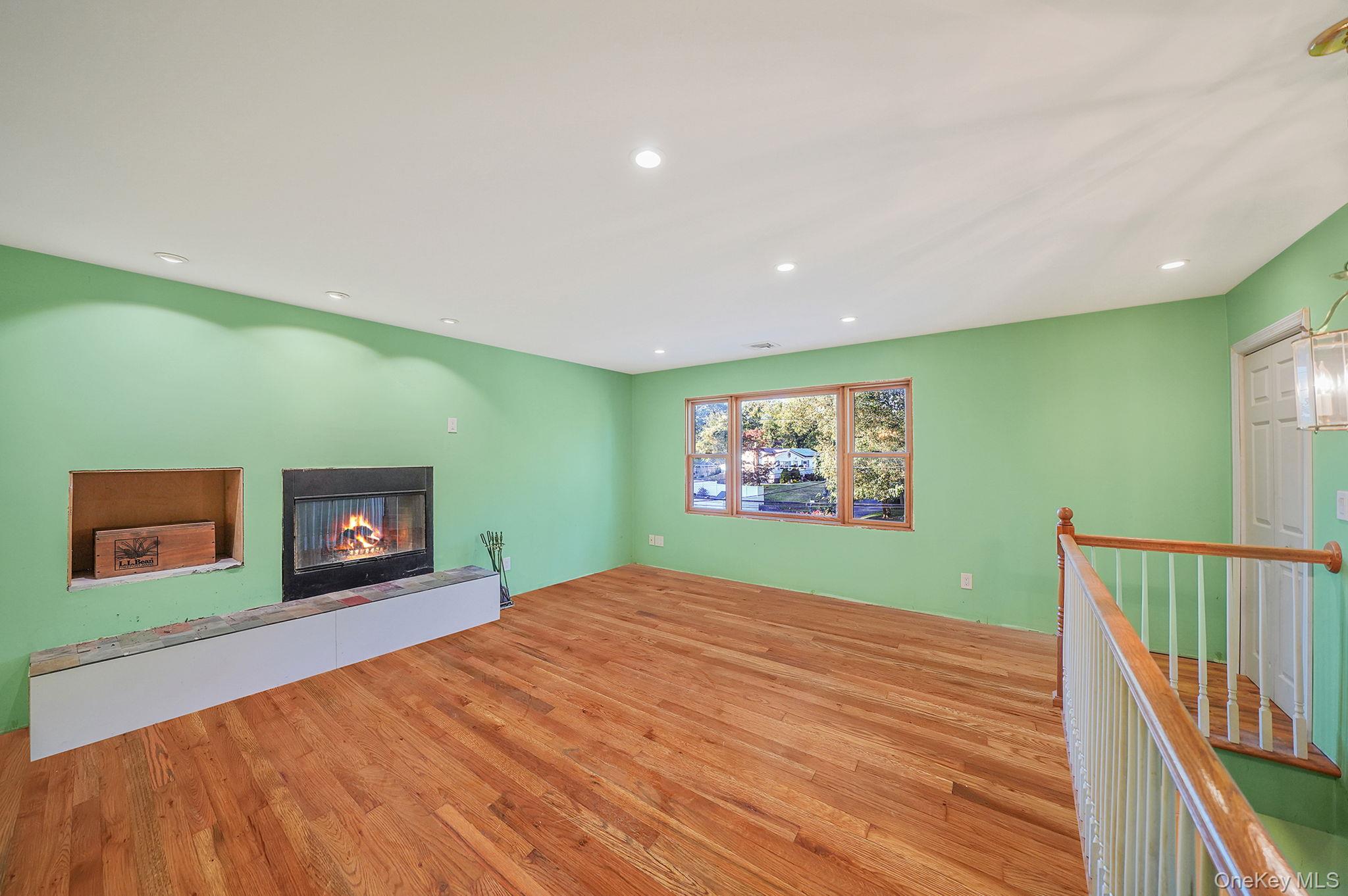 97 Locust Drive Rocky Point, NY 11778 - Photo 9 of 26 Unfurnished living room with recessed lighting, light wood finished floors, and a glass covered fireplace