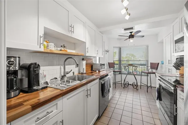 a kitchen with stainless steel appliances granite countertop a sink a stove and cabinets